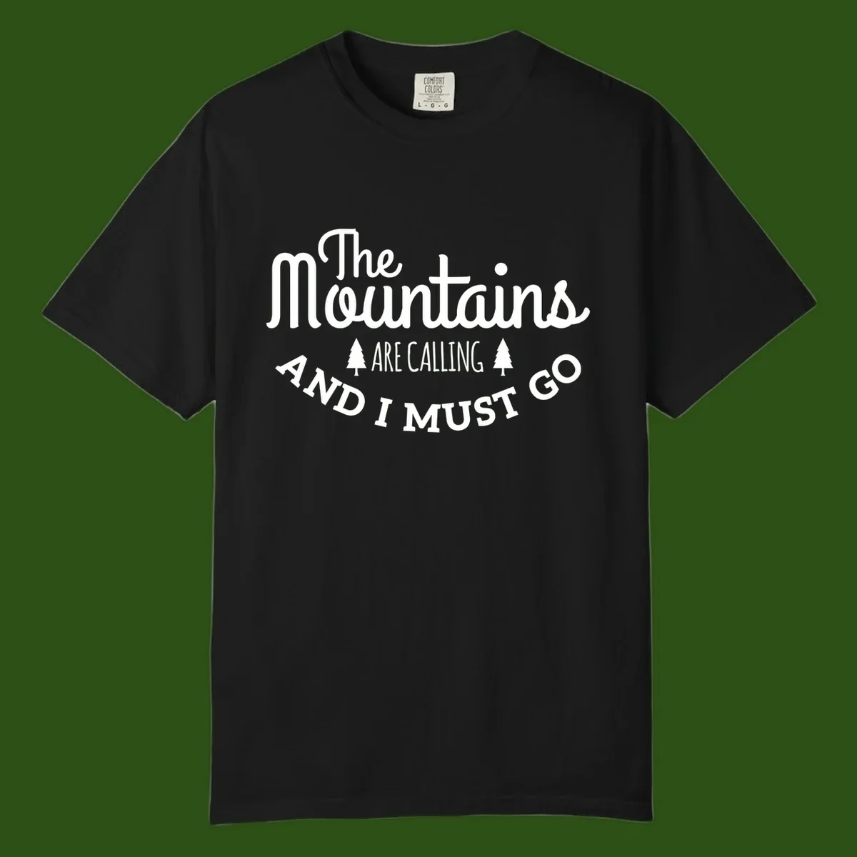 White text reading "The Mountains Are Calling And I Must Go" with pine trees on gray background