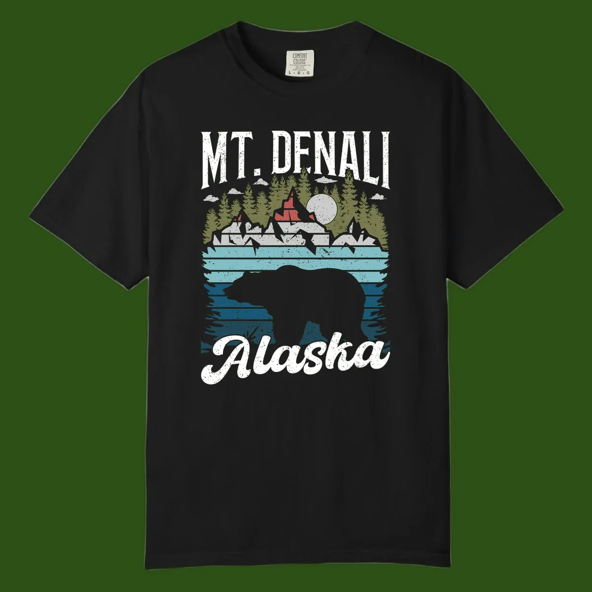 Denali bear Alaska design: layered illustration with silhouetted bear emerging from water, mountain peaks, fortress, forest, and full moon.