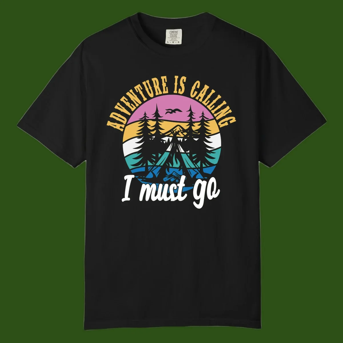 Circular badge with mountain landscape, evergreen trees, and flying birds in pink, gold, white, teal and blue with text 'Adventure Is Calling I Must Go'