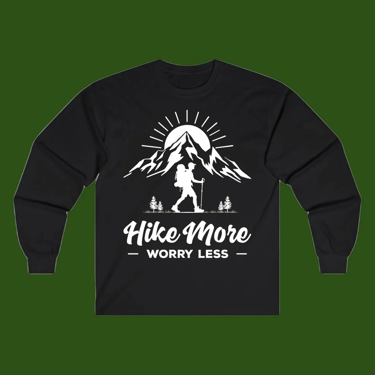 Silhouette of hiker with backpack and poles facing snow-capped mountain with radiating sun, evergreen trees below, text reads 'Hike More Worry Less'