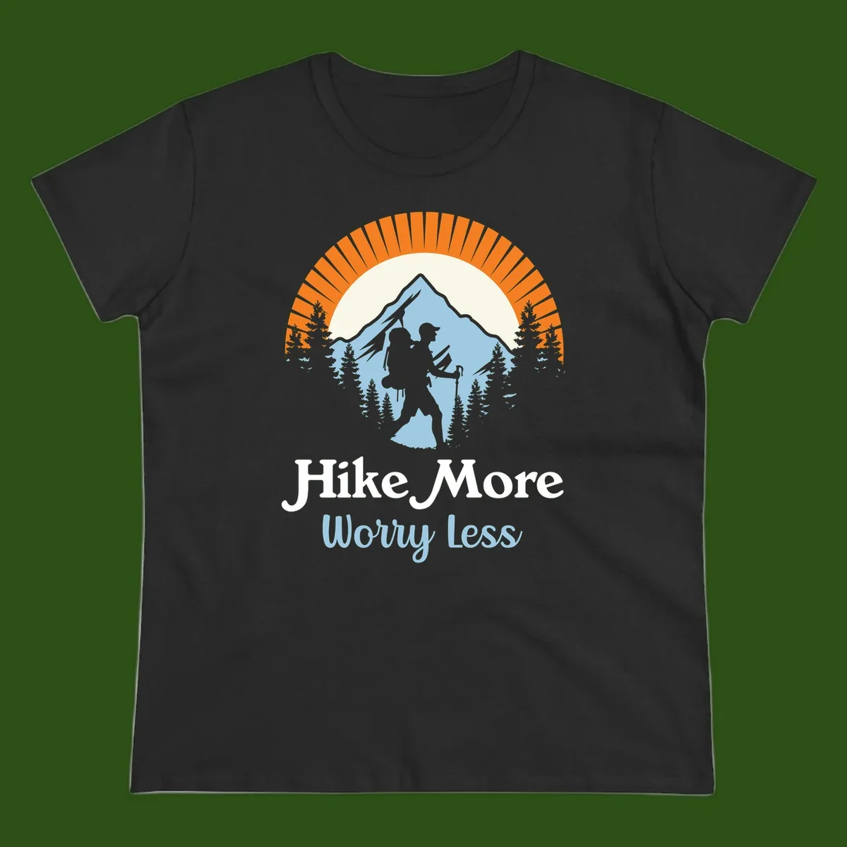 Hike more worry less badge design with silhouetted hiker, mountain peak, and evergreen forest in circular composition.