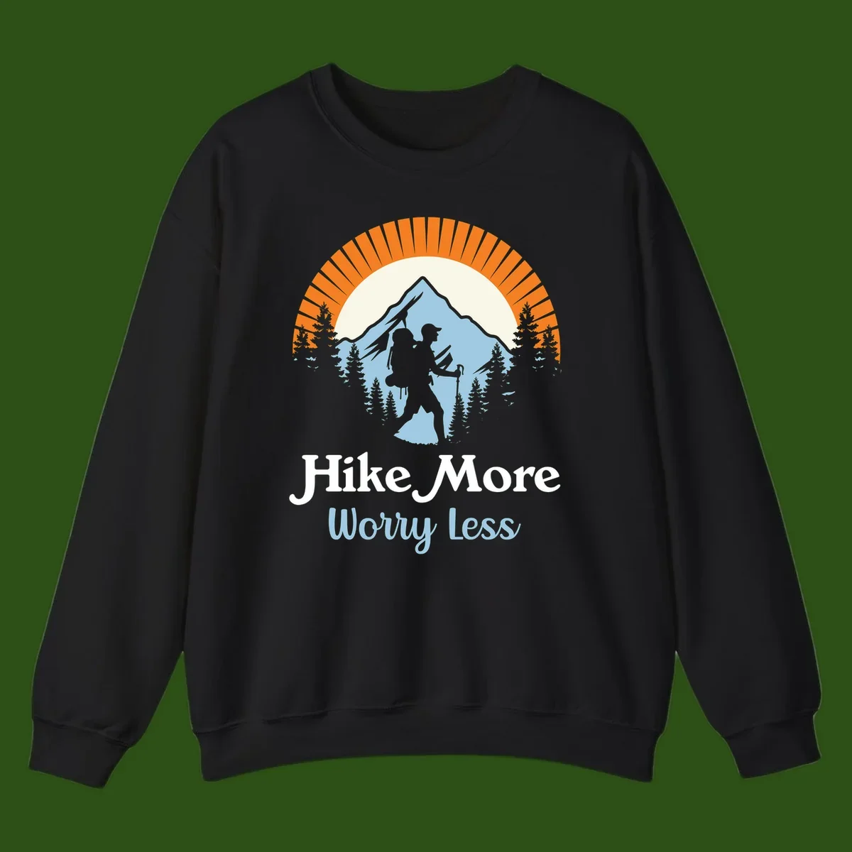 Hike more worry less badge design with silhouetted hiker, mountain peak, and evergreen forest in circular composition.