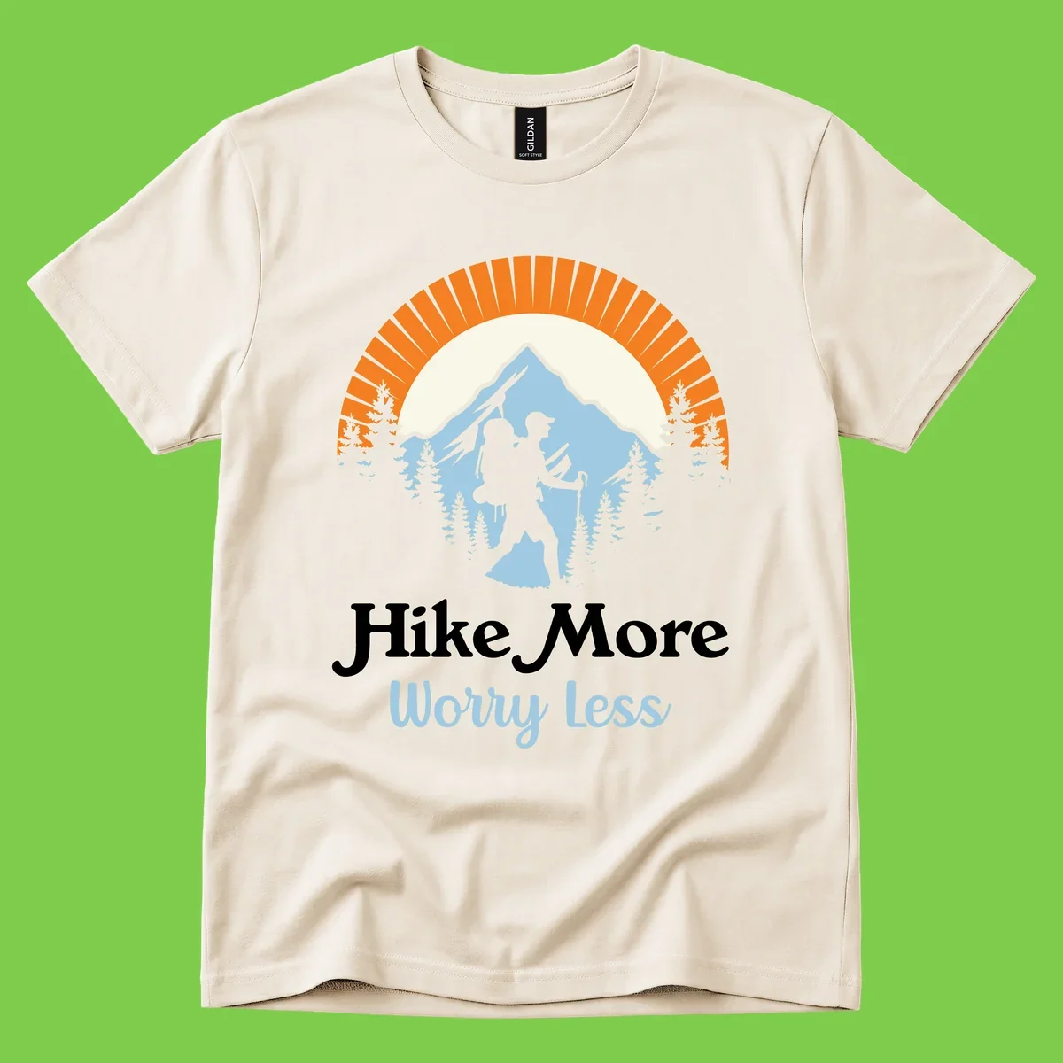 Hike more worry less badge design with silhouetted hiker, mountain peak, and evergreen forest in circular composition.