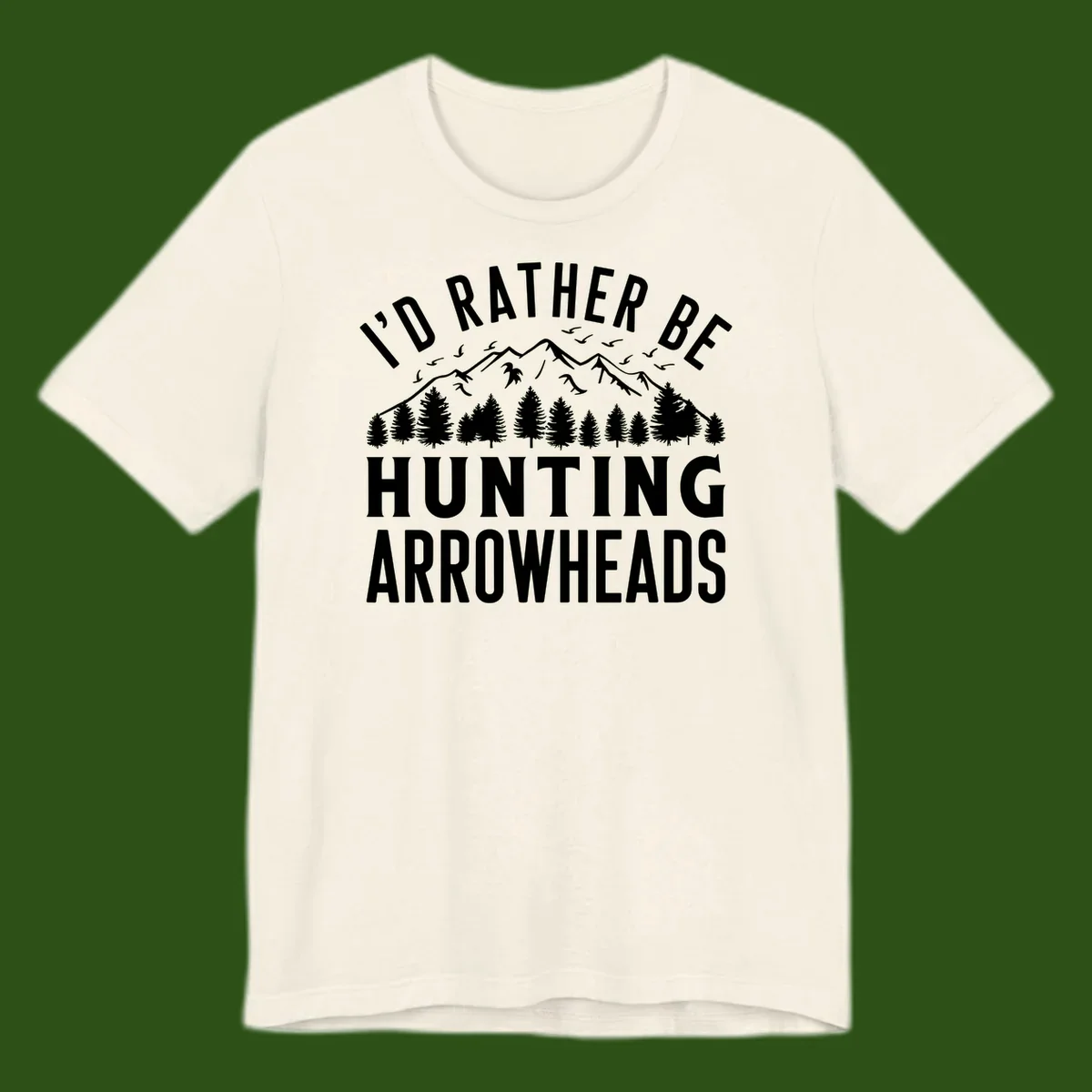 Mountain landscape with evergreen trees and birds, white text reading 'I'd Rather Be Hunting Arrowheads' on gray background