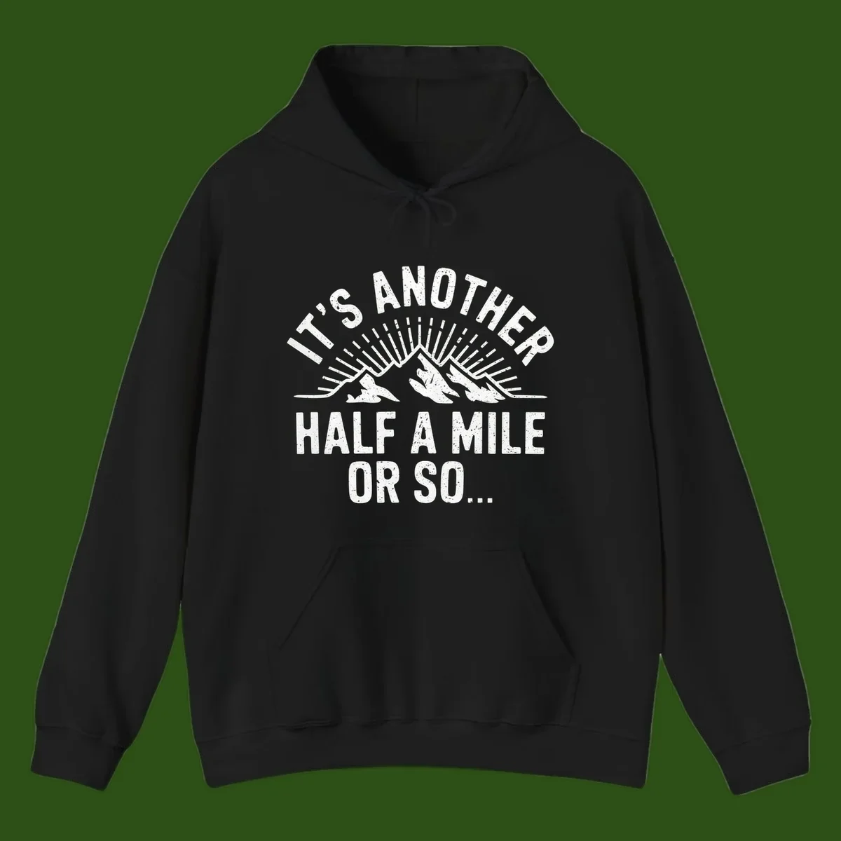 Retro distressed design with mountain peaks and sun rays, text reads 'It's Another Half A Mile Or So' - humorous hiking and camping artwork