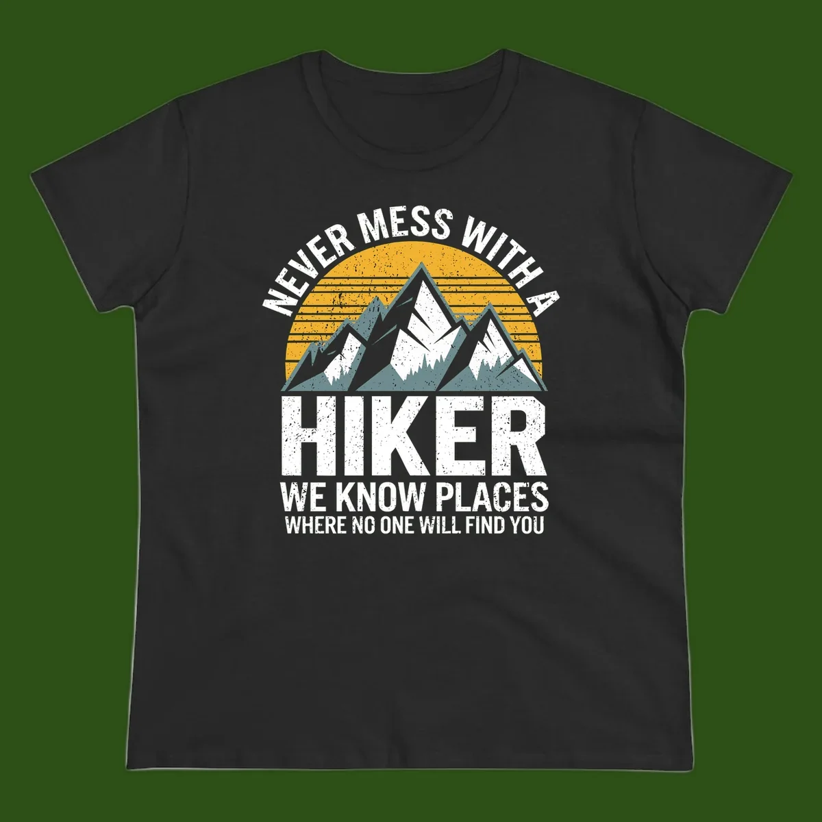 Vintage-style design with snow-capped mountains and forest silhouette against striped sunset, text reads 'Never Mess With A Hiker We Know Places Where No One Will Find You'