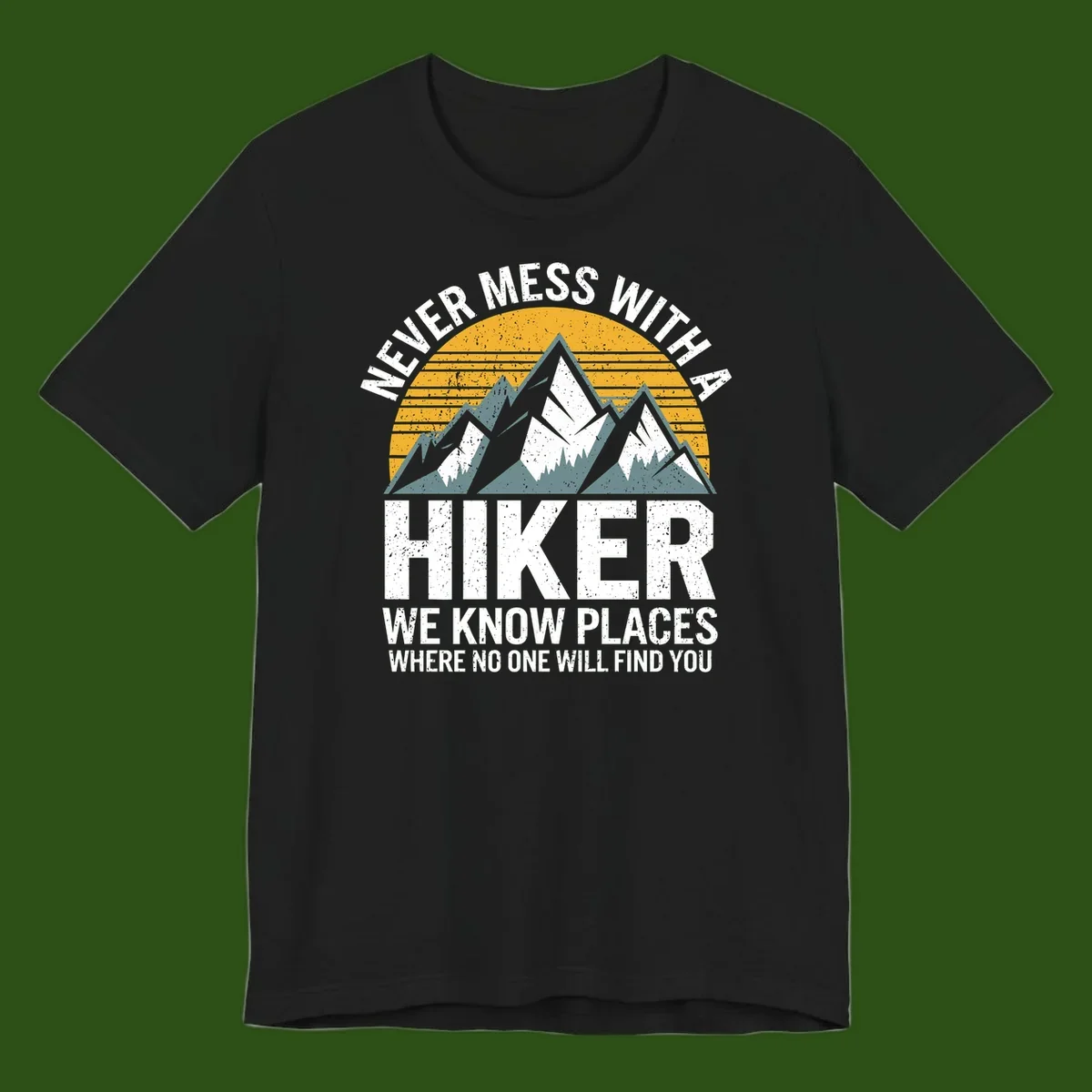 Vintage-style design with snow-capped mountains and forest silhouette against striped sunset, text reads 'Never Mess With A Hiker We Know Places Where No One Will Find You'