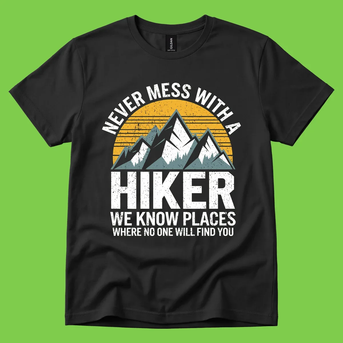 Vintage-style design with snow-capped mountains and forest silhouette against striped sunset, text reads 'Never Mess With A Hiker We Know Places Where No One Will Find You'