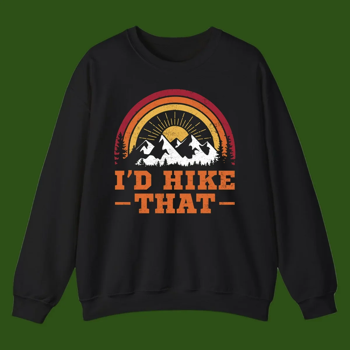Vintage badge design with snow-capped mountains, evergreen trees, golden sun rays, and text reading 'I'd Hike That' in retro style