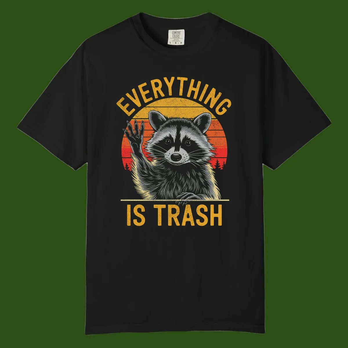 Vintage-style illustration of a raccoon with raised paw against retro sunset stripes, text reading 'Everything Is Trash' in distressed gold lettering