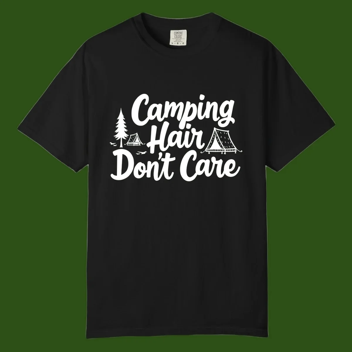 White text reading 'Camping Hair Don't Care' with illustrated tent and evergreen tree designs on gray background