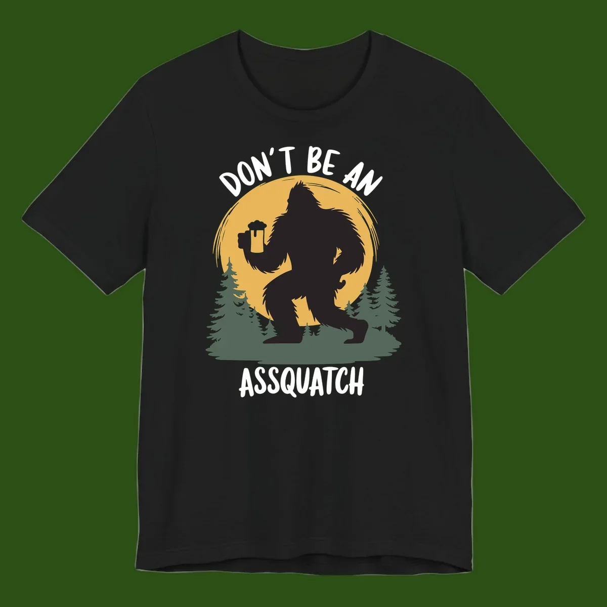 Black silhouette of Bigfoot holding a beer mug under a full moon with pine trees, text reads don't be an assquatch