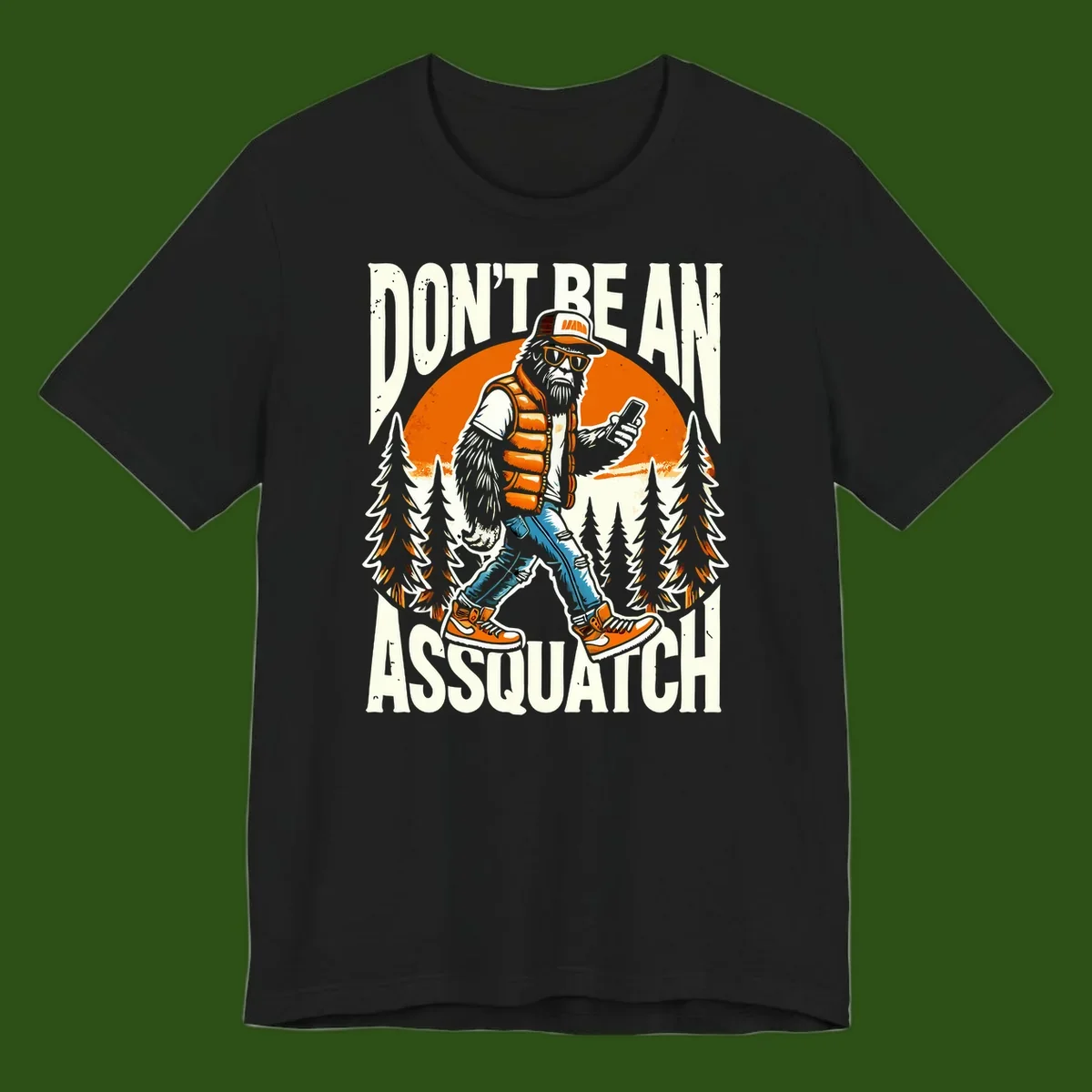 Cartoon sasquatch in hiking gear with backpack and smartphone, 'Don't Be An Assquatch' text, forest and orange sun background.
