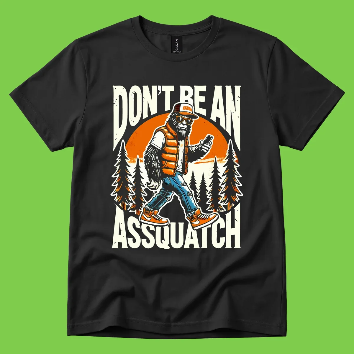 Cartoon sasquatch in hiking gear with backpack and smartphone, 'Don't Be An Assquatch' text, forest and orange sun background.