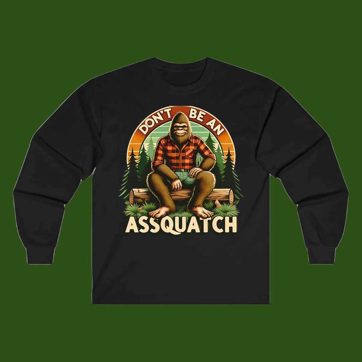 Vintage badge design with friendly Bigfoot in plaid shirt sitting on a log with forest trees, text reads 'Don't Be An Assquatch'