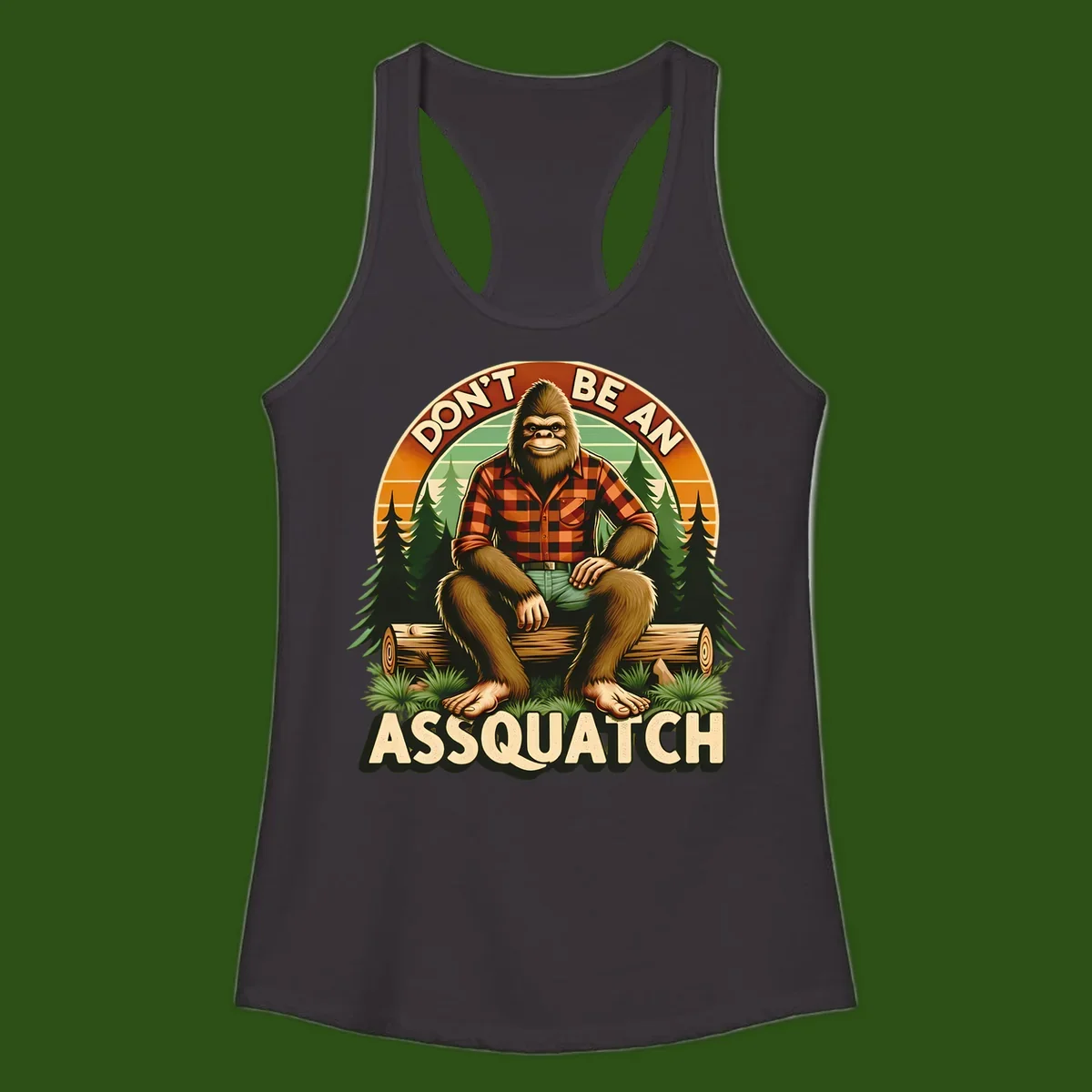 Vintage badge design with friendly Bigfoot in plaid shirt sitting on a log with forest trees, text reads 'Don't Be An Assquatch'