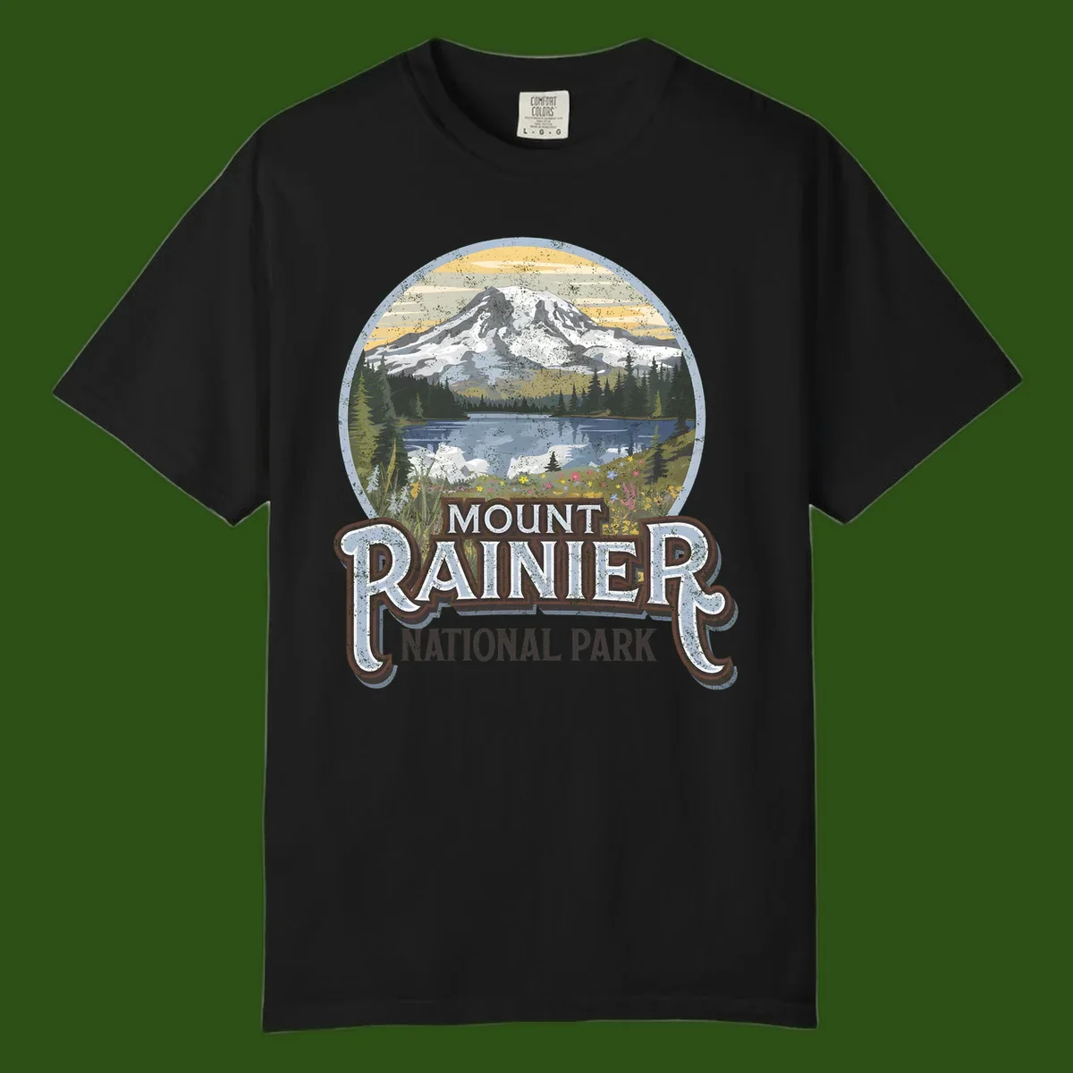 Vintage Mount Rainier National Park badge design with snow-capped peak, alpine lake, evergreen forest, and wildflowers on distressed background