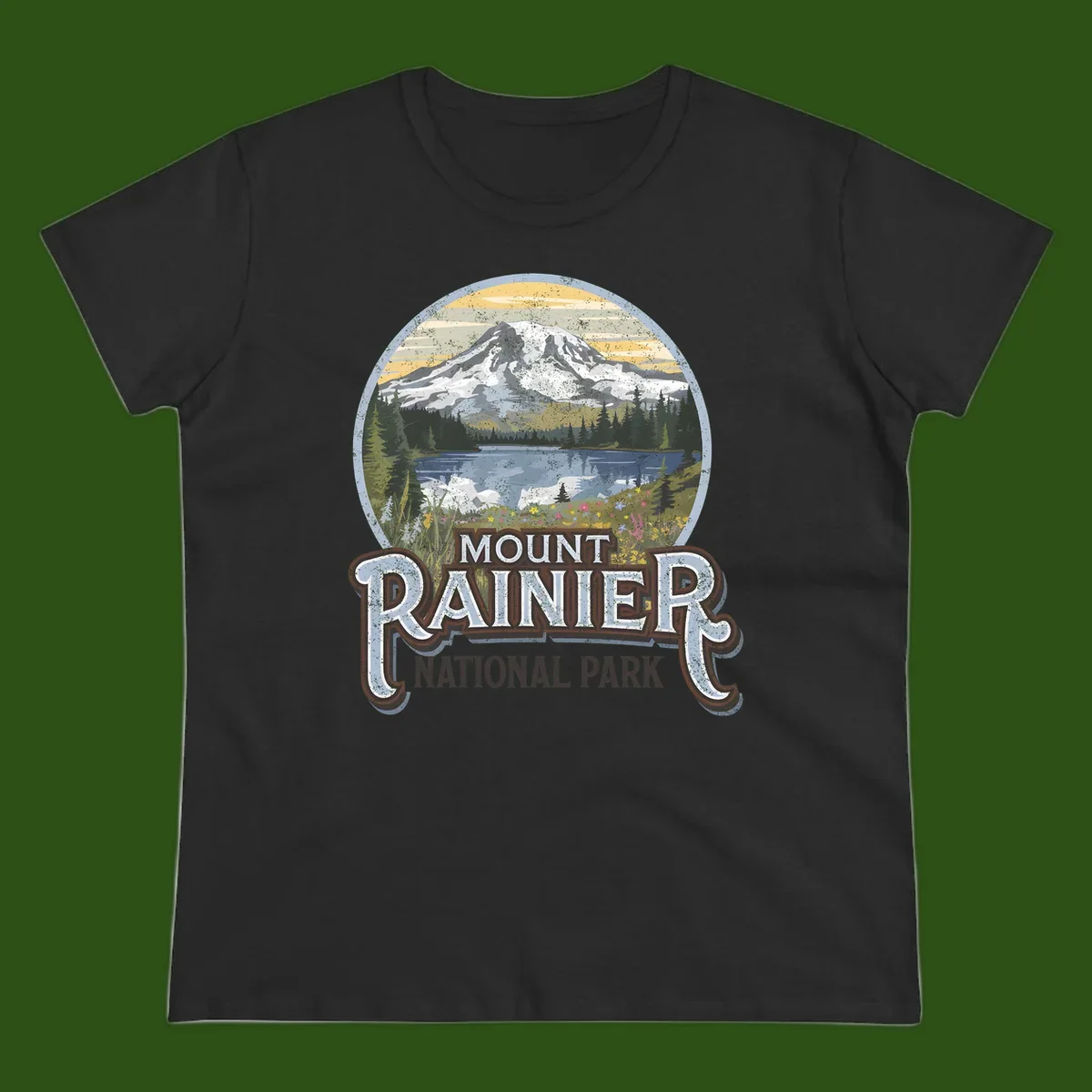 Vintage Mount Rainier National Park badge design with snow-capped peak, alpine lake, evergreen forest, and wildflowers on distressed background