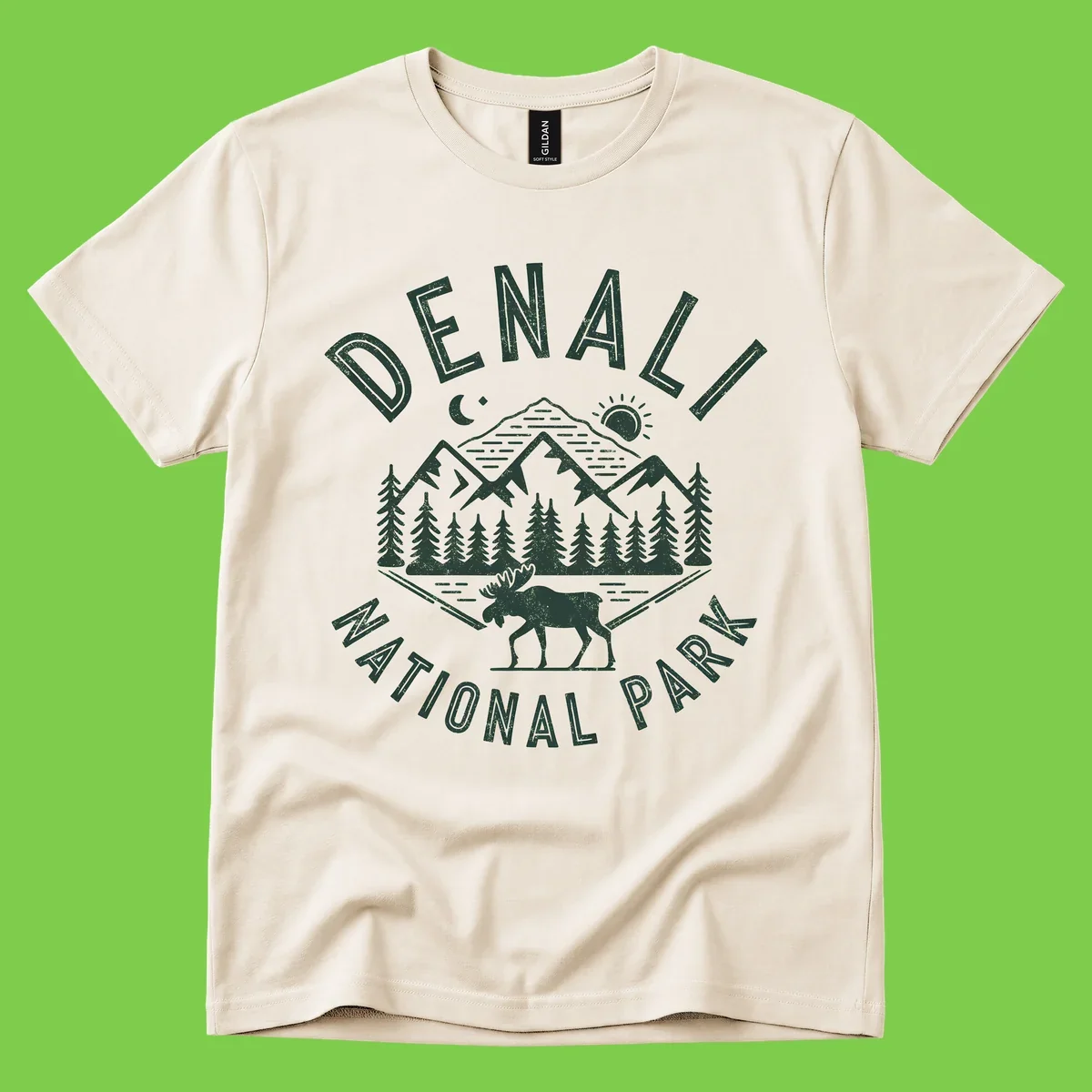 Denial National Park badge design with moose walking through forest, mountains, sun and moon with crossed fishing rods