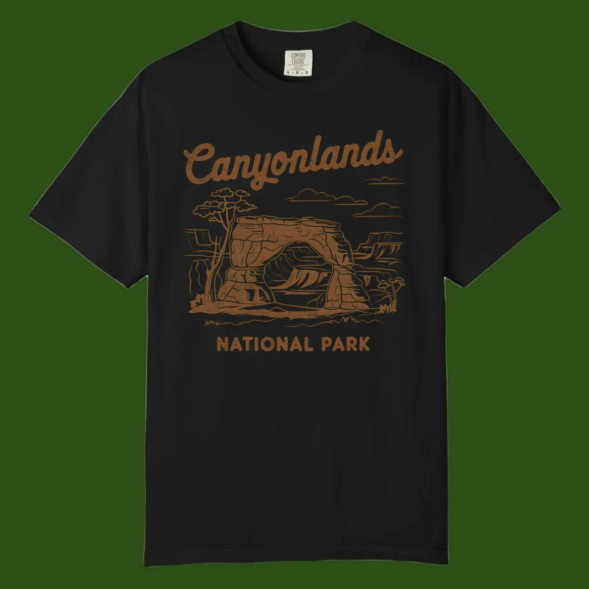 Vintage illustration of Canyonlands National Park featuring layered red rock canyon formations, desert acacia tree, and clouds in rust orange line art.