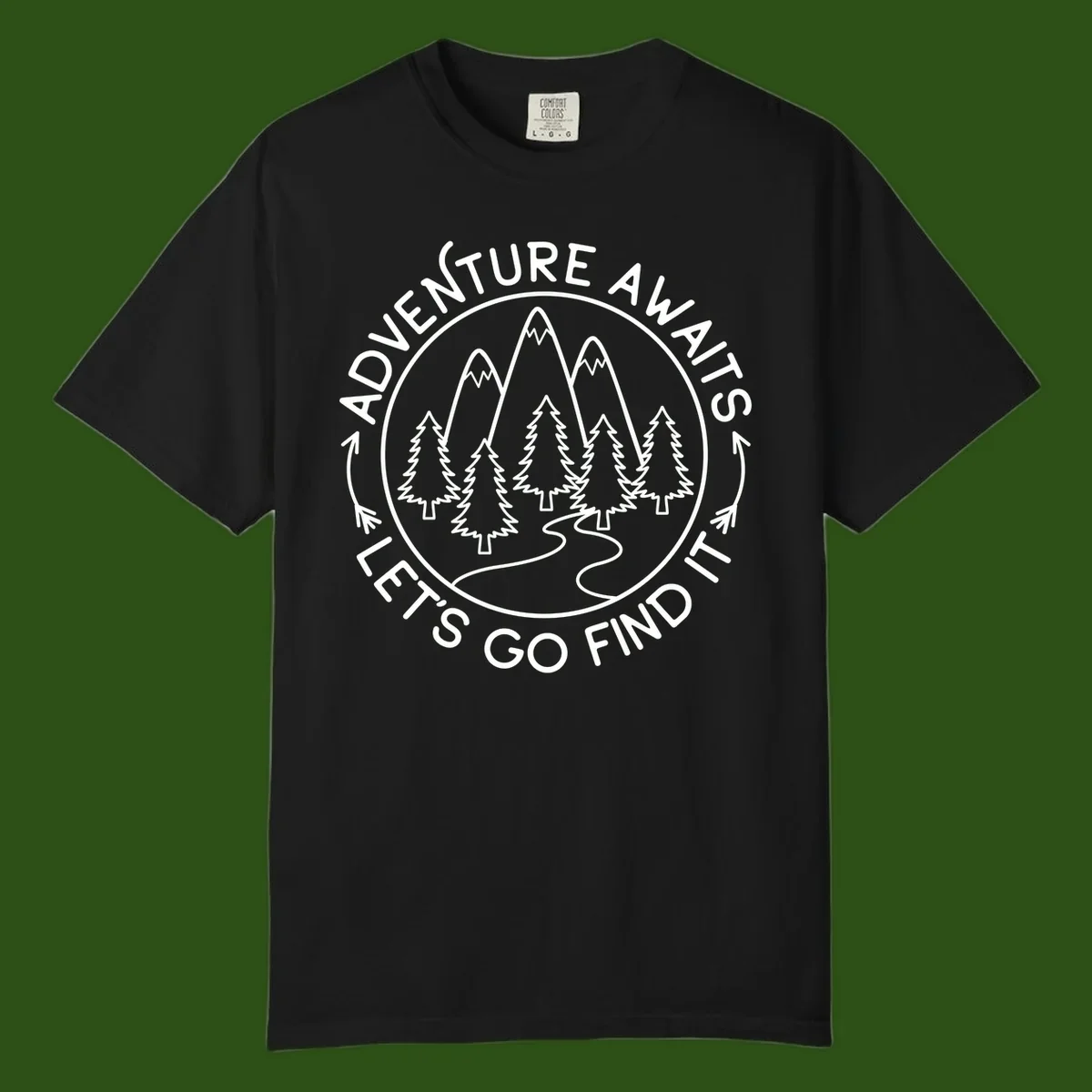 Circular badge with forest scene of evergreen trees and mountains, text reads 'Adventure Awaits Let's Go Find It'