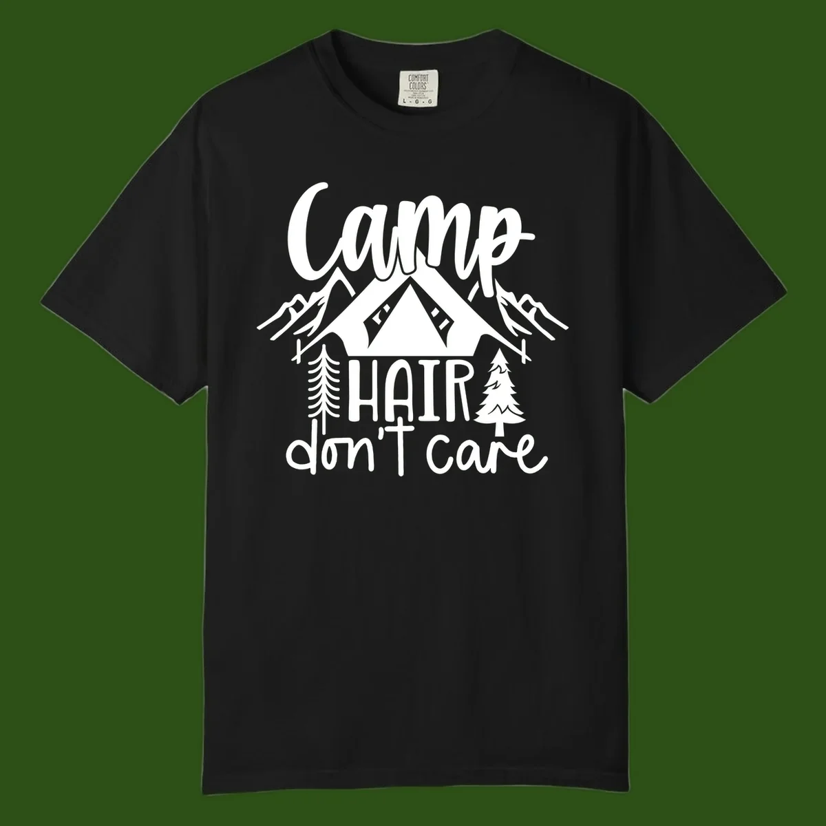 Camp hair don't care design with tent, mountains, pine trees, and campfire illustration with cursive text