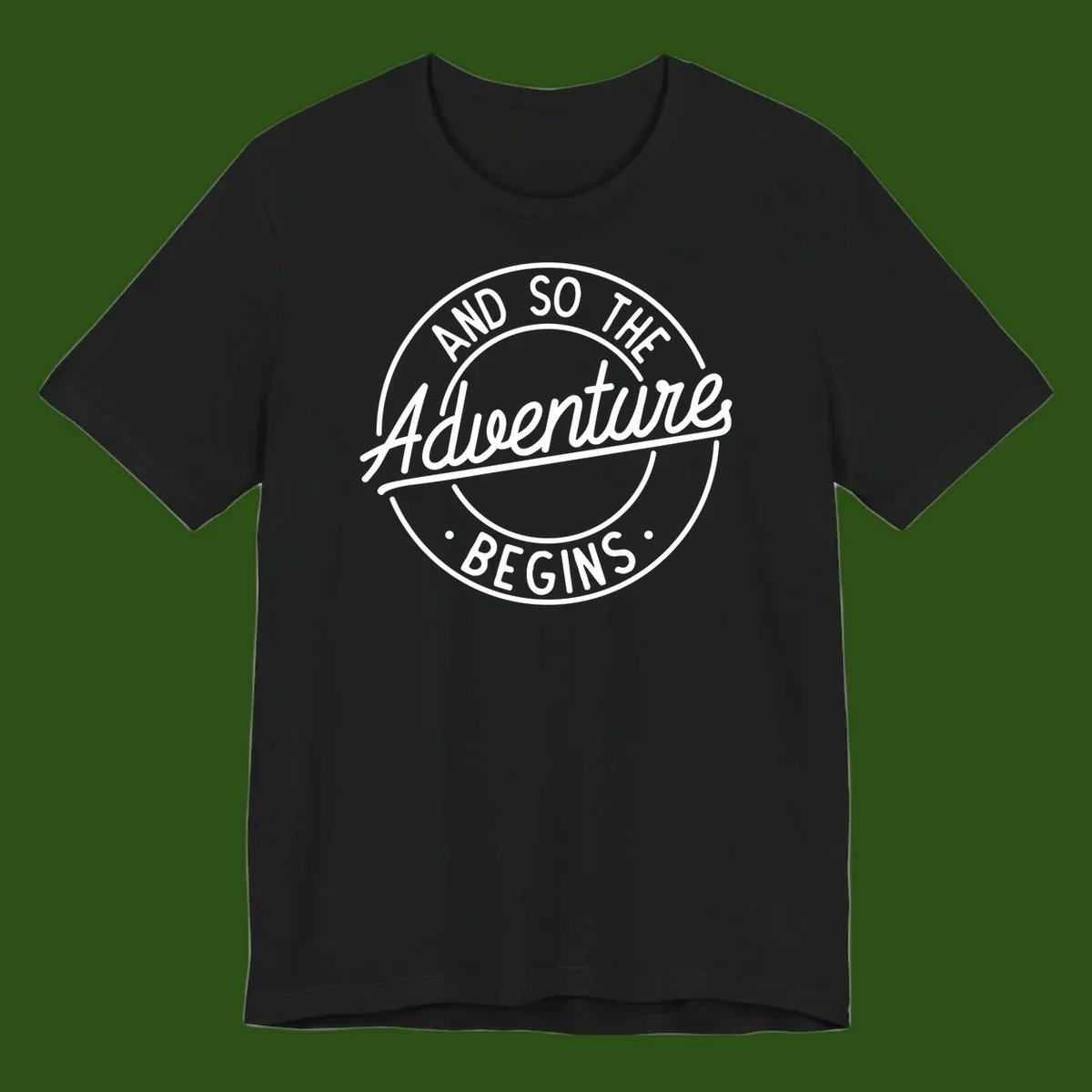 Vintage circular badge design with white text reading 'And So The Adventure Begins' on gray background