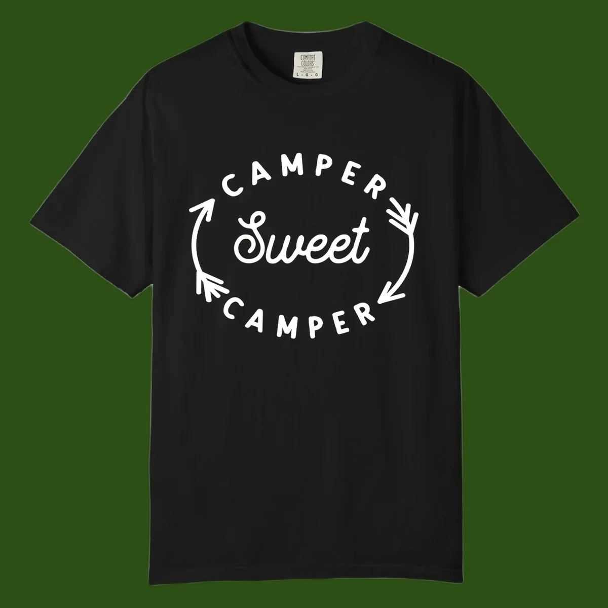 Circular badge design with 'Camper Sweet Camper' text and pine branch decorations in white on gray background