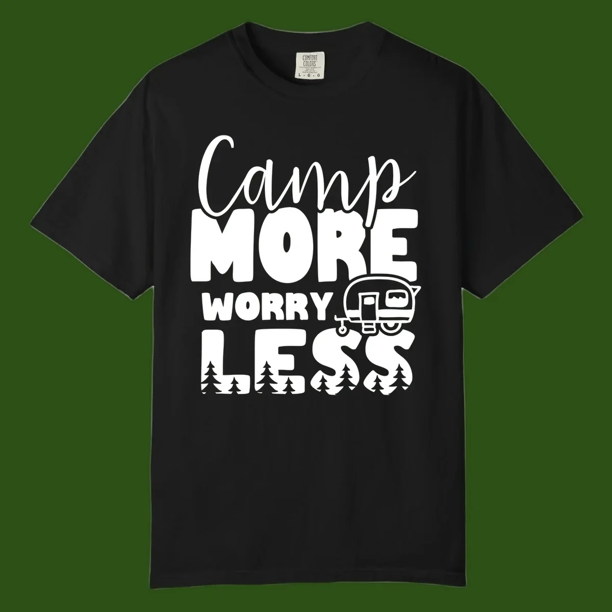 Camp More Worry Less design with flowing script text, camping trailer, and pine trees on gray background