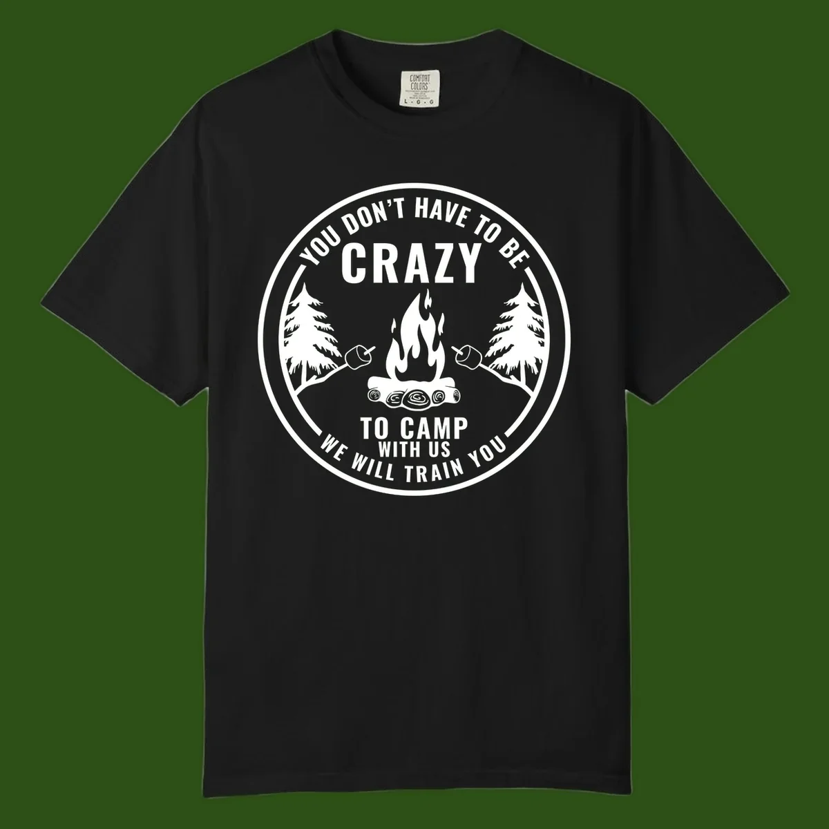 Circular badge design with campfire, pine trees, and marshmallows on sticks with humorous camping text about training crazy campers