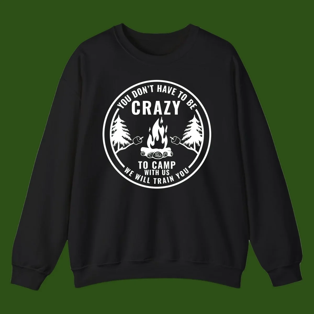 Circular badge design with campfire, pine trees, and marshmallows on sticks with humorous camping text about training crazy campers