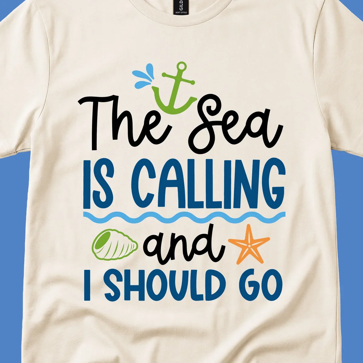 Gray tee design with 'The Sea Is Calling and I Should Go' text in white and blue, decorated with nautical icons including anchor, starfish, seashell, and ocean waves.