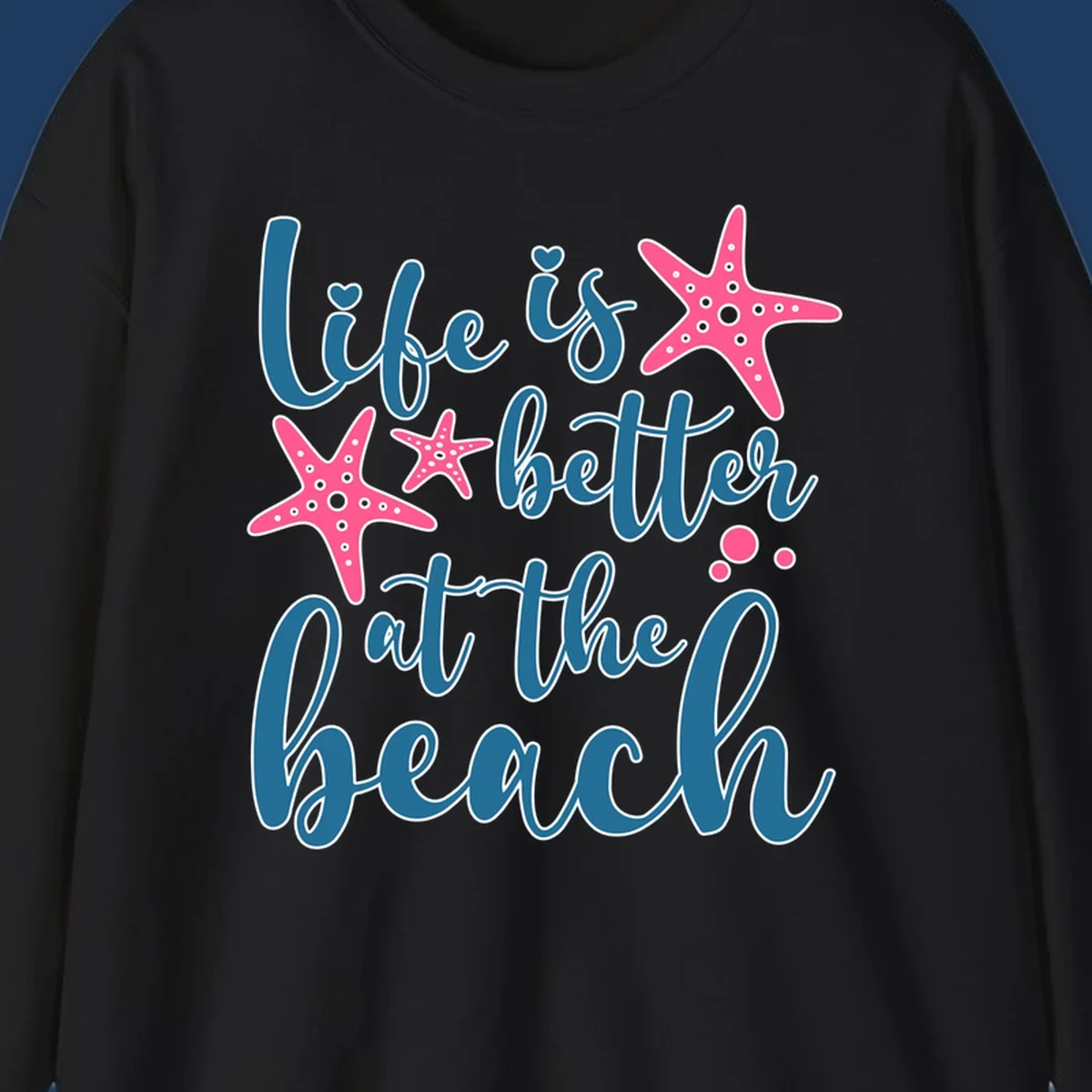 Life is better at the beach design with teal cursive text, pink starfish with white dots, and bubbles on gray background