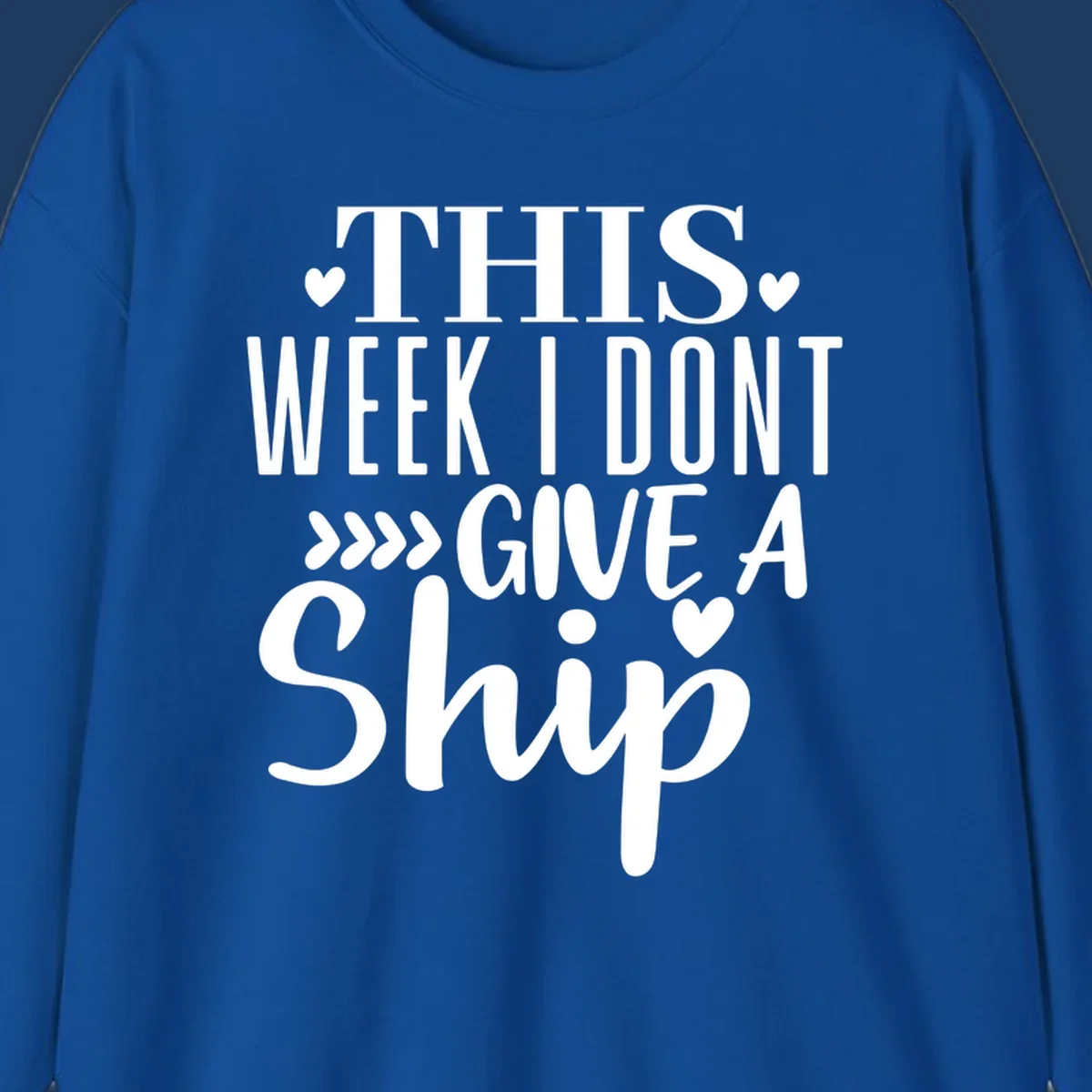 White text on gray background reading 'This Week I Don't Give A Ship' with hearts and arrows, a playful cruise humor design