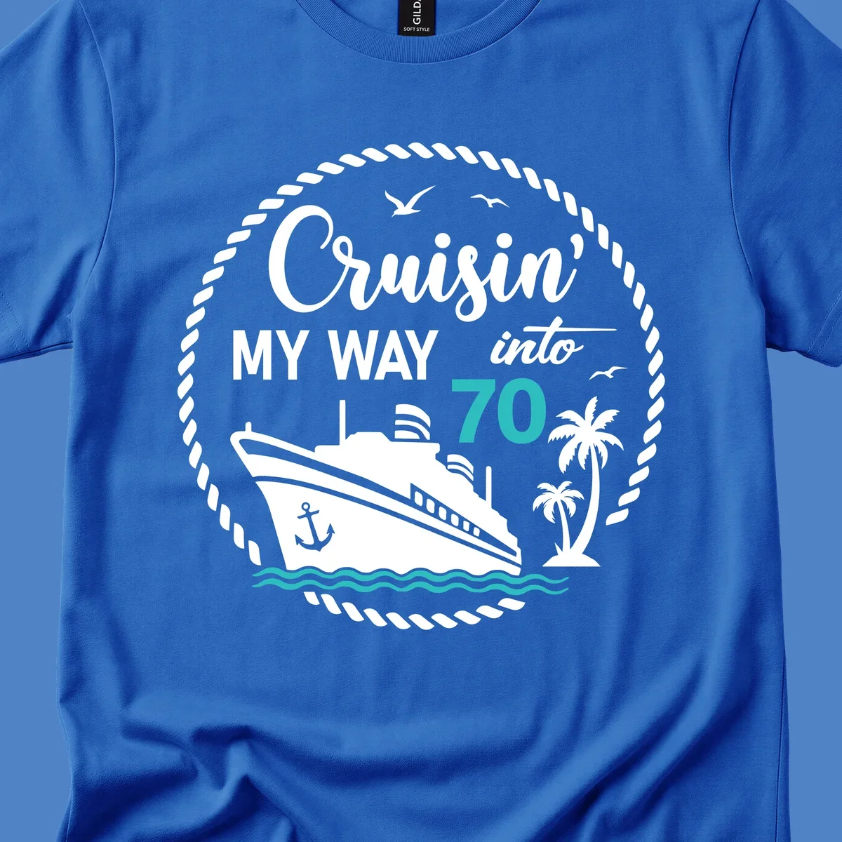 Nautical 70th birthday design with cruise ship, palm trees, and waves. Text reads 'Cruisin' MY WAY into 70' in white and teal on gray background.