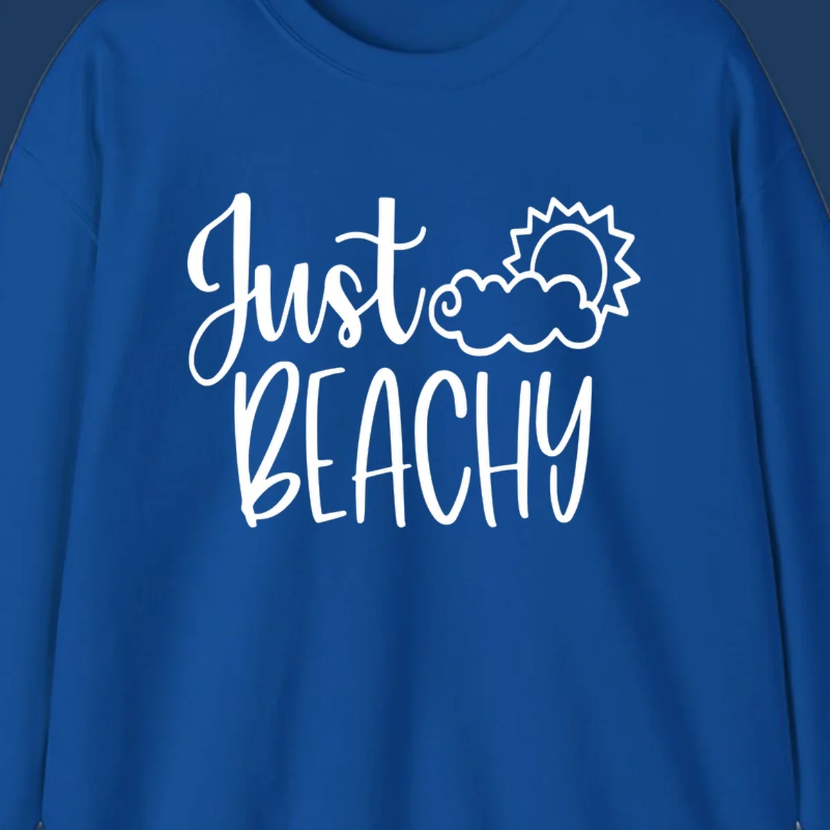 White illustrated text reading 'Just Beachy' with a smiling sun and cloud graphic, capturing beach vacation vibes