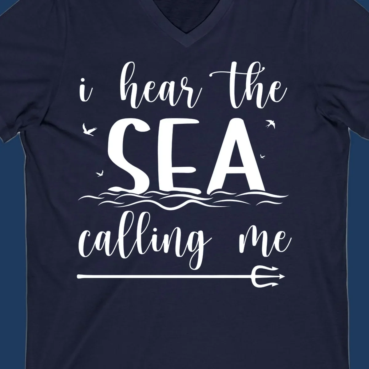 White nautical design with 'i hear the SEA calling me' text, ocean waves, seabirds, and trident anchor on gray background