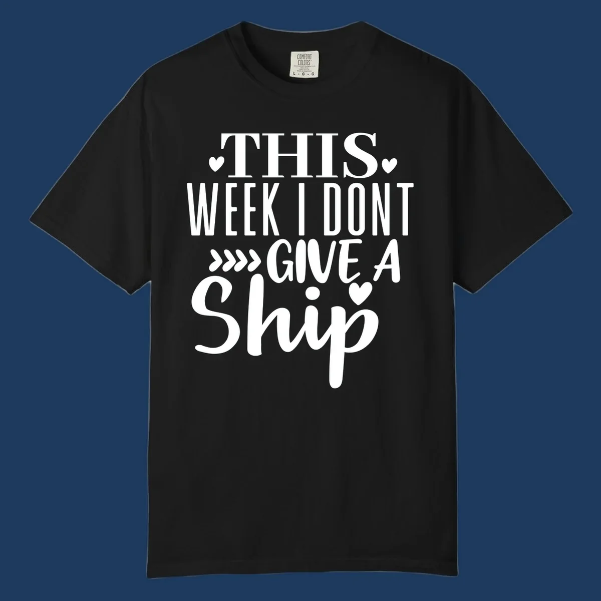 White text on gray background reading 'This Week I Don't Give A Ship' with hearts and arrows, a playful cruise humor design