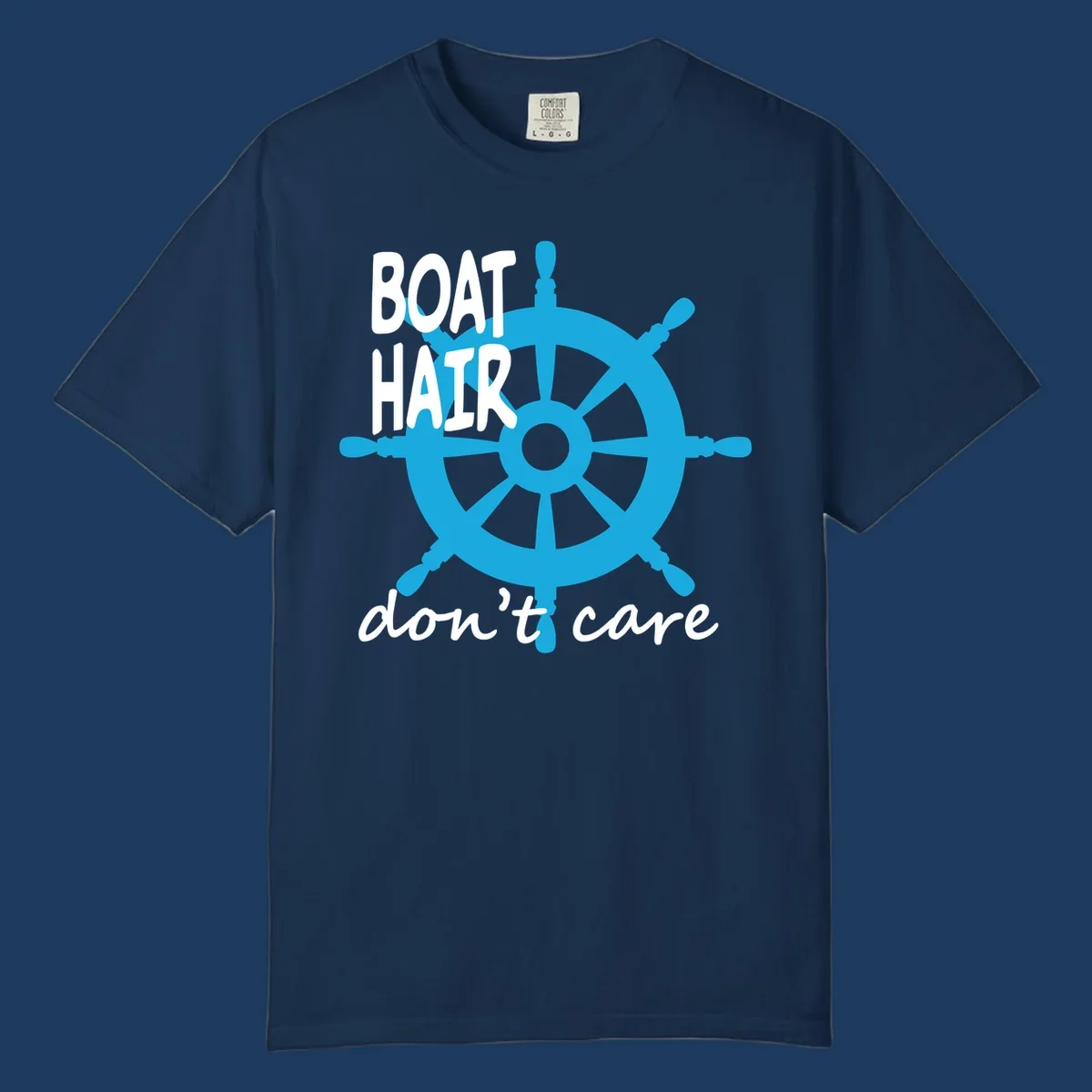 Blue ship's wheel graphic with white text reading 'BOAT HAIR don't care' - nautical cruise humor design