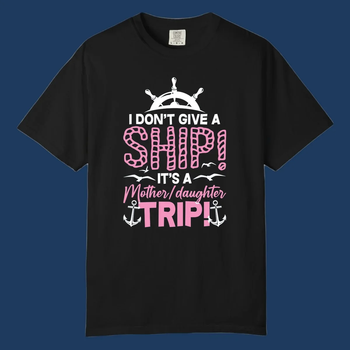 Gray design with ship wheel, anchors, and pink textured lettering reading 'I Don't Give A Ship It's A Mother Daughter Trip' - a nautical cruise humor design