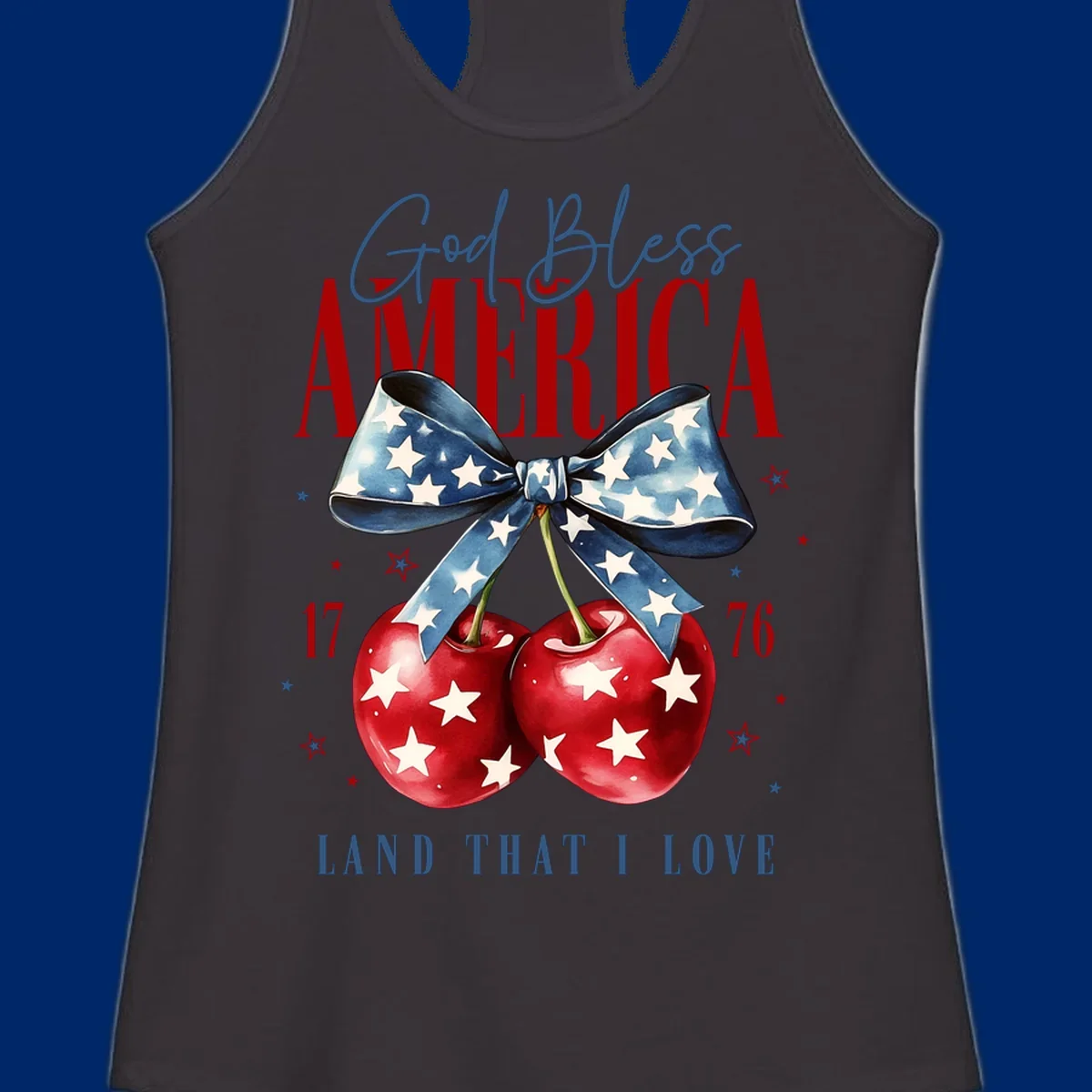 A patriotic design featuring 'God Bless AMERICA' and 'LAND THAT I LOVE' with a blue star-spangled bow, two red star-covered cherries, and the numbers '17' and '76'. god-bless-america-cherries.