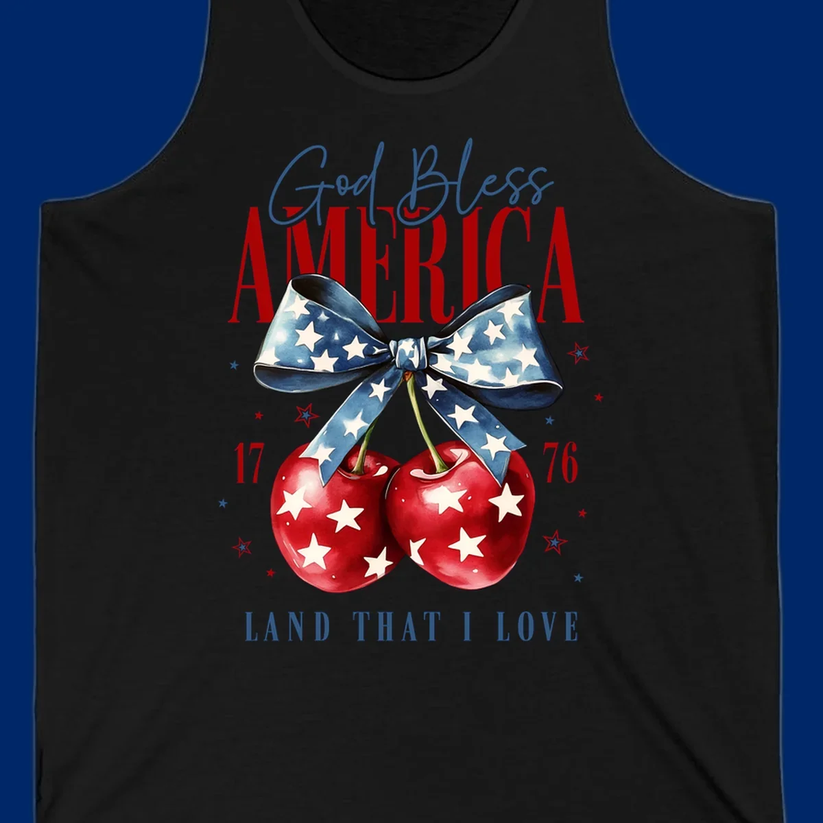 A patriotic design featuring 'God Bless AMERICA' and 'LAND THAT I LOVE' with a blue star-spangled bow, two red star-covered cherries, and the numbers '17' and '76'. god-bless-america-cherries.
