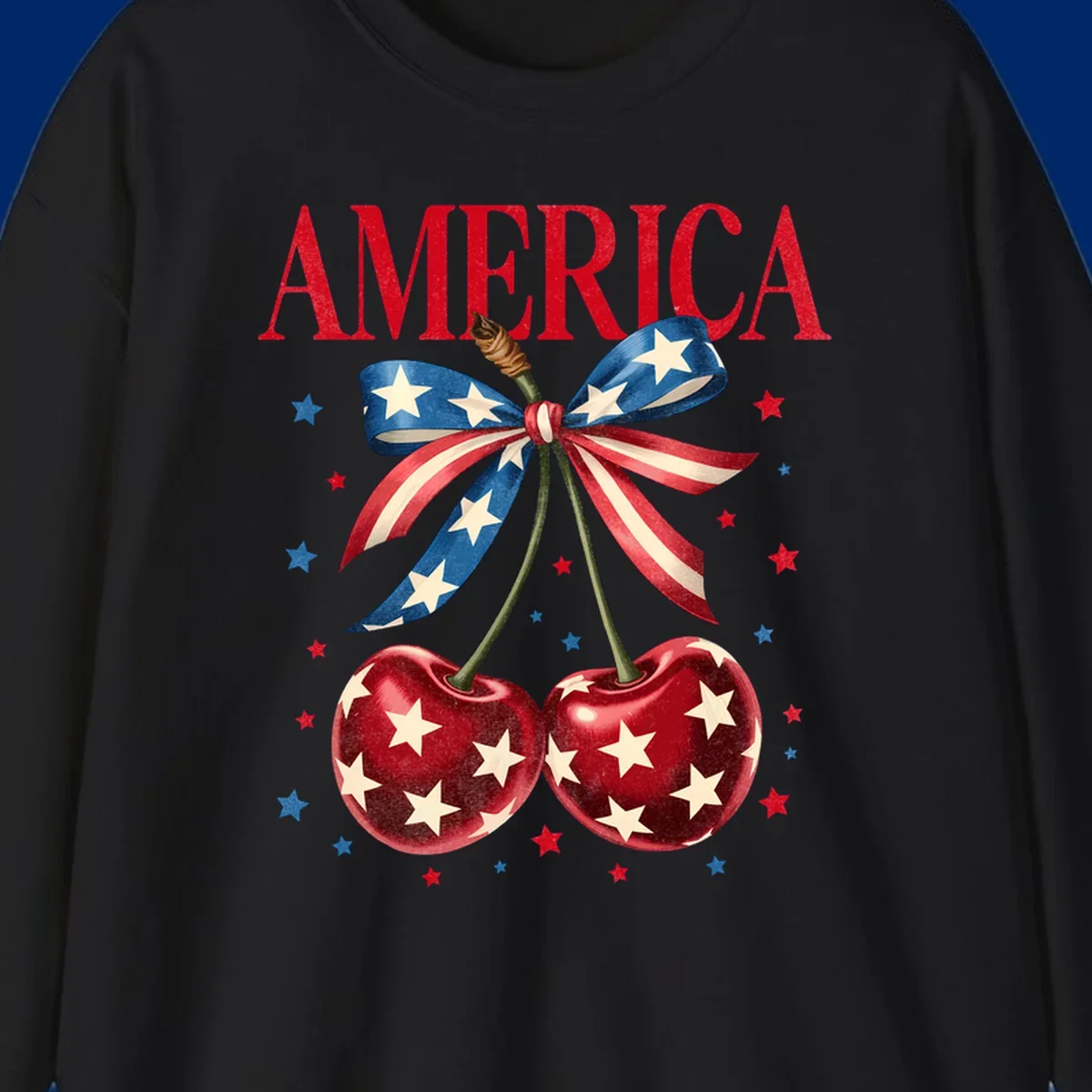 Vintage patriotic artwork featuring red 'AMERICA' text, two red cherries with white stars, and an American flag ribbon. Scattered red and blue stars complete this America-cherries-stars design.