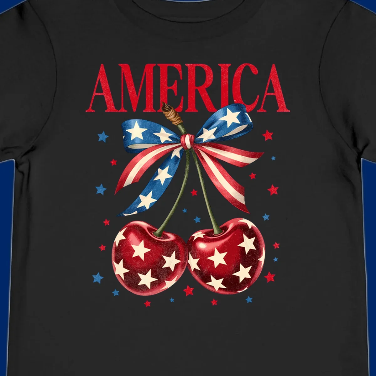 Vintage patriotic artwork featuring red 'AMERICA' text, two red cherries with white stars, and an American flag ribbon. Scattered red and blue stars complete this America-cherries-stars design.