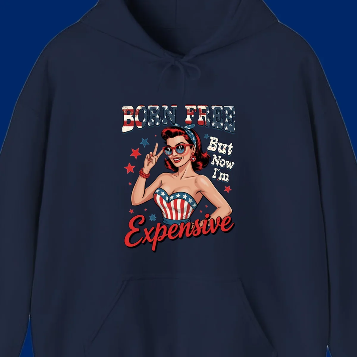 Retro pin-up girl making a peace sign, wearing a stars and stripes top, with the text 'BORN FREE But Now I'm Expensive'. This born-free-expensive-pin-up design is patriotic and fun.