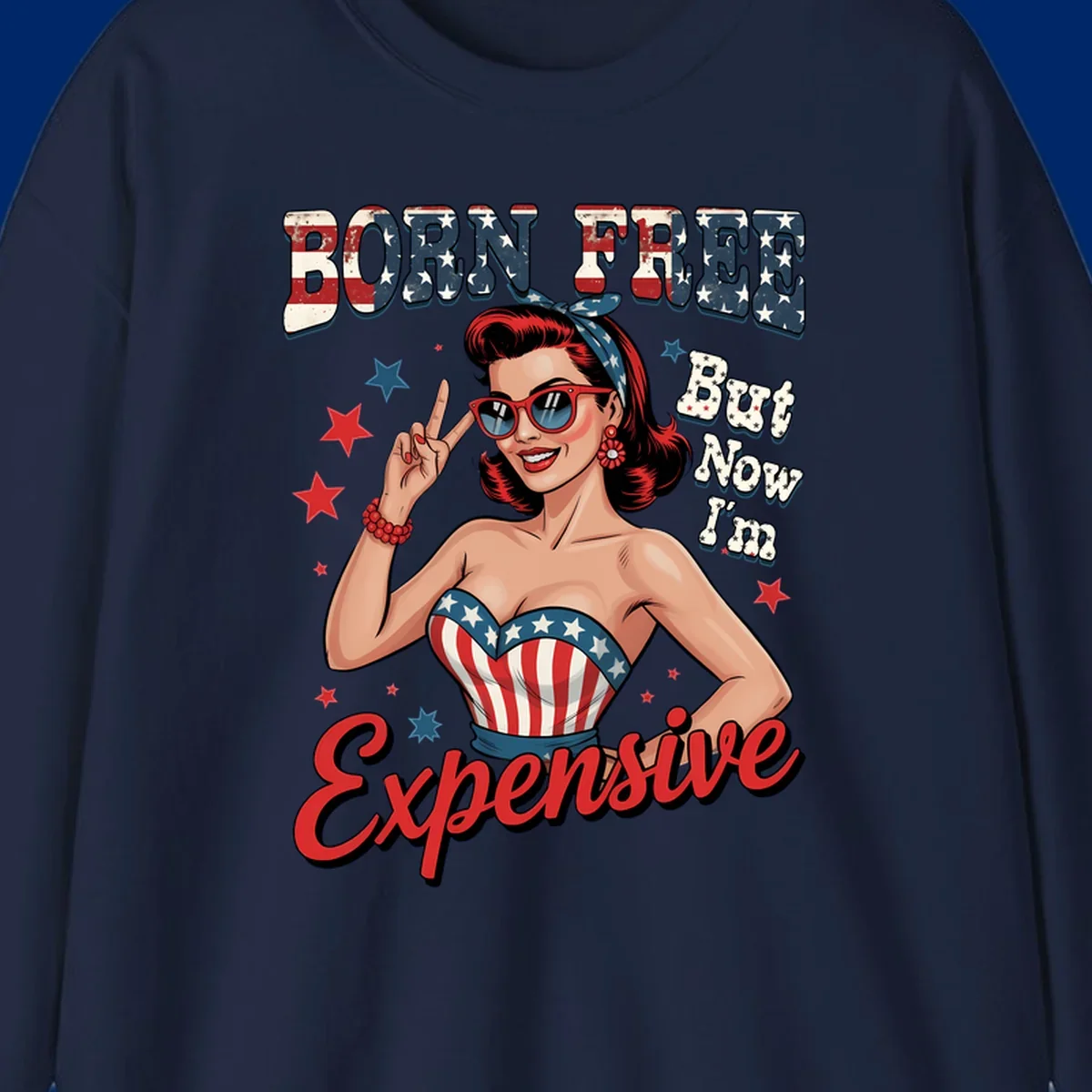 Retro pin-up girl making a peace sign, wearing a stars and stripes top, with the text 'BORN FREE But Now I'm Expensive'. This born-free-expensive-pin-up design is patriotic and fun.