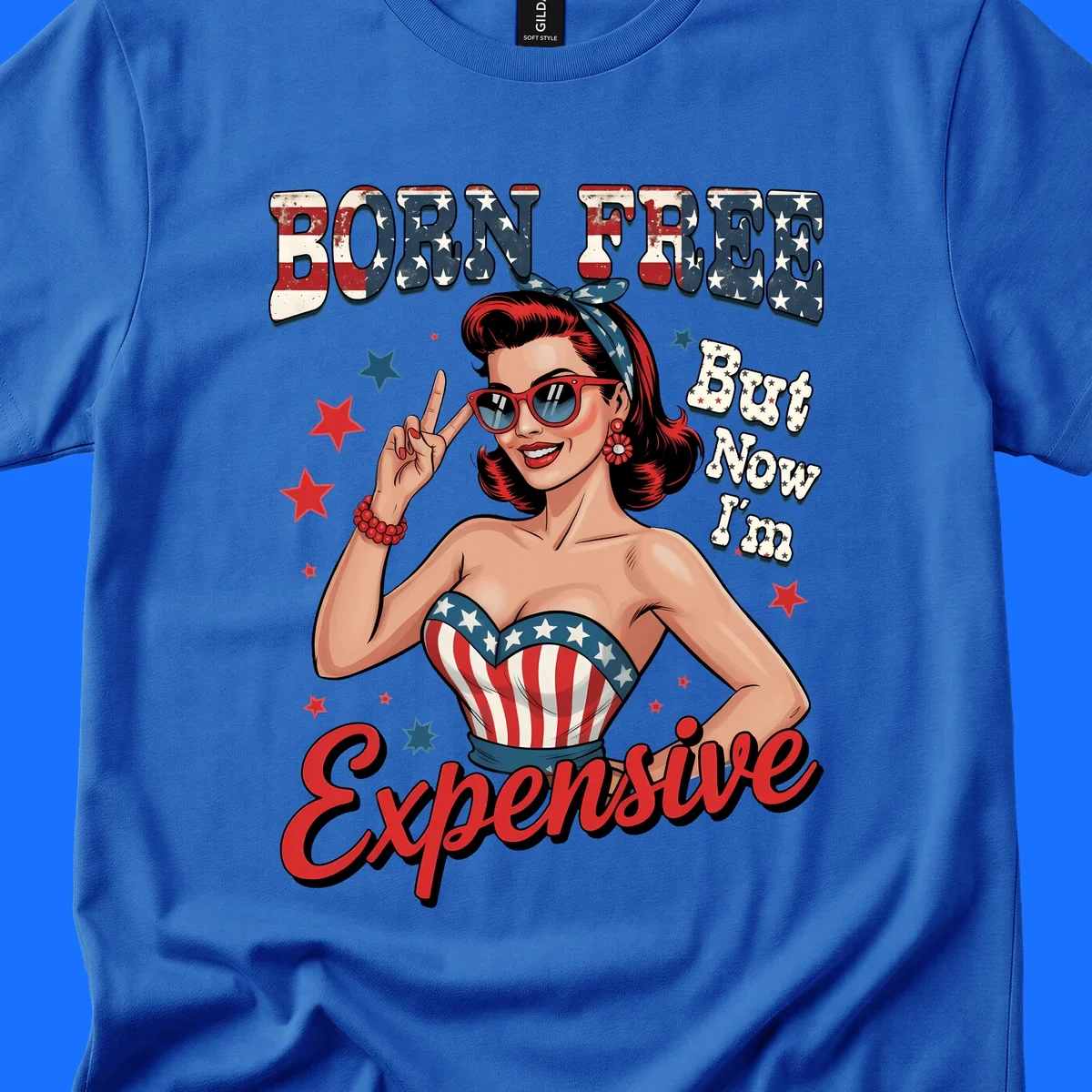 Retro pin-up girl making a peace sign, wearing a stars and stripes top, with the text 'BORN FREE But Now I'm Expensive'. This born-free-expensive-pin-up design is patriotic and fun.