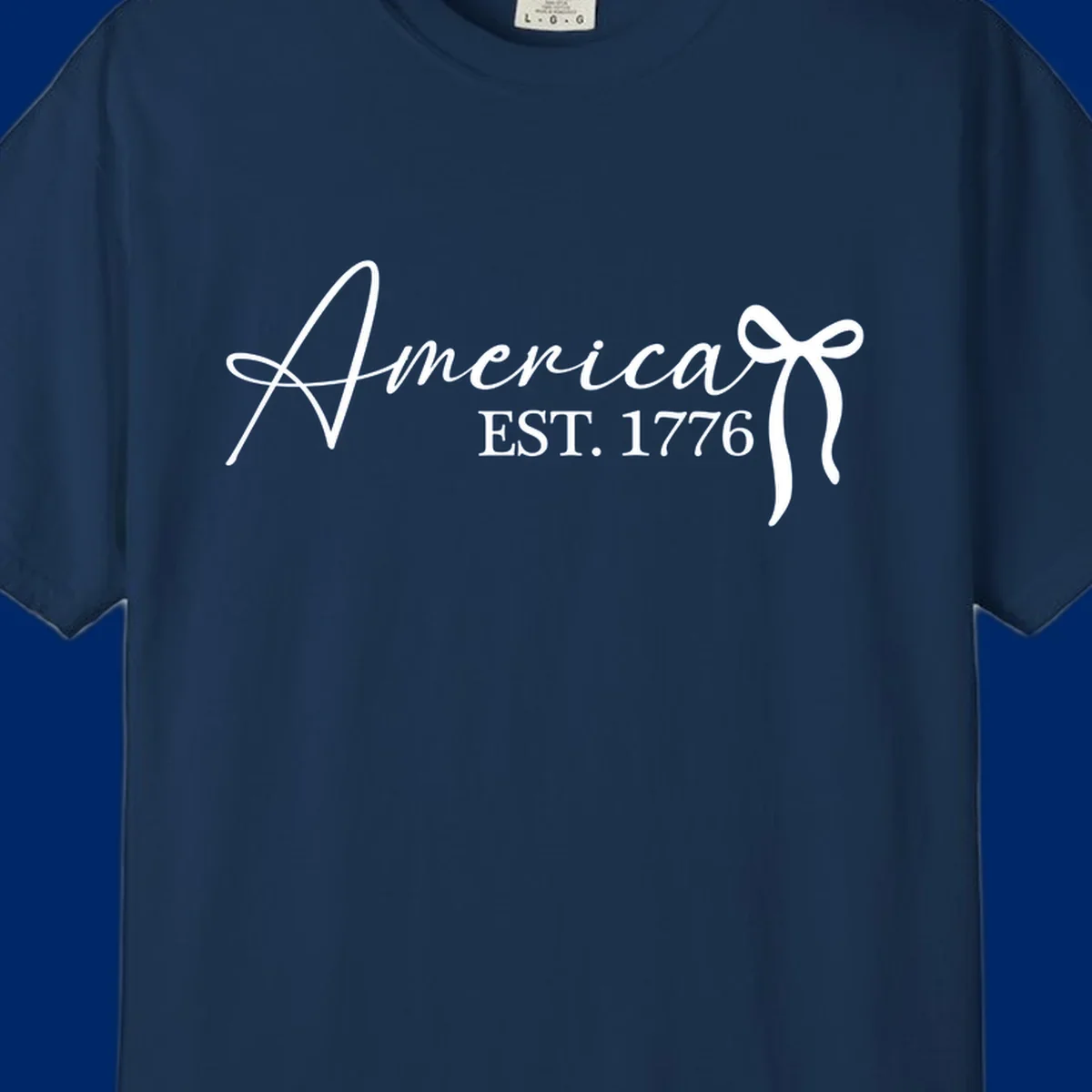 White script text "America" with decorative flourishes above "EST. 1776" in serif font, on a black background. Design for america-est-1776.