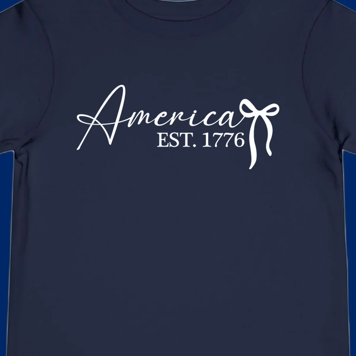 White script text "America" with decorative flourishes above "EST. 1776" in serif font, on a black background. Design for america-est-1776.
