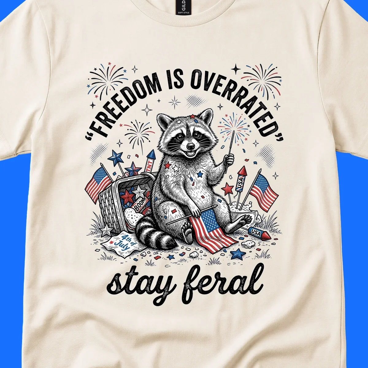 A black and white illustration of a feral raccoon celebrating July 4th with fireworks, American flags, and the text 'FREEDOM IS OVERRATED' and 'stay feral'.
